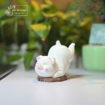 Heo gốm trắng nằm trên đế gỗ decor bàn làm việc