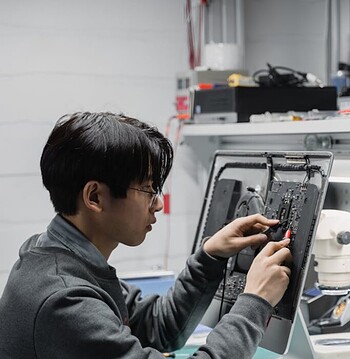 A skilled technician diagnosing and repairing computer hardware indoors.
