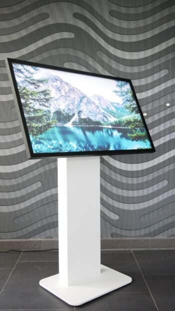 Das Bild zeigt das S-Kiosk Touchterminal von der Seite mit 43 Zoll Touchscreen und weißer Stele von SIMONS Production Company