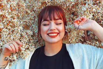 Woman in leaves smiling. Begin ptsd therapist in detroit, mi now!