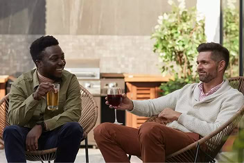 Two coworkers share a drinks during a happy hour in the outdoor space of a Raleigh bar