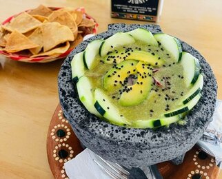 Aguachile con Pepino Aguachile con pepino servido en un molcajete, acompañado de totopos.