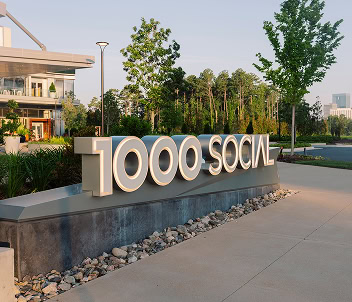 An illuminated sign welcomes visitors and employees to 1000 Social, a luxury office and coworking space in Midtown Raleigh