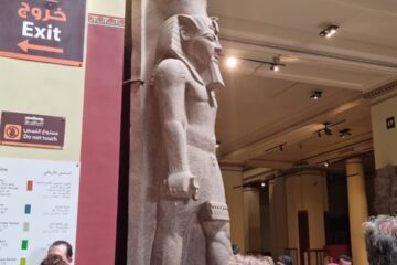 Touristen bestaunen eine antike Statue im Ägyptischen Museum in Kairo während eines Marsa Alam Pyramiden Ausflugs.