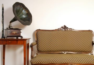 mobili vintage; piccolo divano vintage a due posti, piccolo mobiletto rosso e giradischi con grammofono