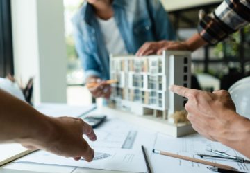 sopraelevazione condominiale, uomini discutono lavori condominiali con modellino