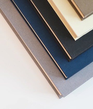 hero-img-01 A stack of minimalist hardcover books in varied colors, viewed from above.