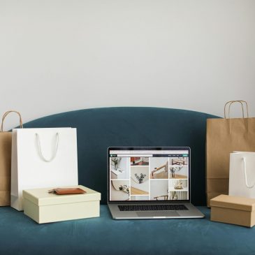 Macbook Pro With Shopping Bags and Boxes On Blue Couch