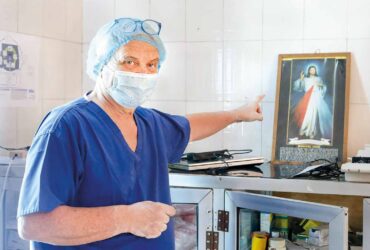 András Csókay, węgierski neurochirurg pokazuje na obraz Jezusa Miłosiernego