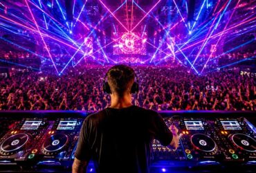 Koncert muzyki techno widziany zza pleców DJ'a