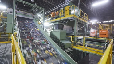 Industrial waste management facility with recycling containers and hazardous material storage areas