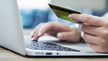 Kobieta płacąca za zakupy internetowe kartą kredytową