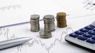 Analizy i wykresy na tle stosu pieniędzy i kalkulatora