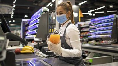 Kasjerka w sklepie w maseczce ochronnej