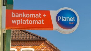 szyld na budynku z napisem bankomat, wpłatomat, logo Planet Cash