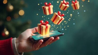 człowiek trzymający w dłoni smartfon, wirtualne paczki prezentów