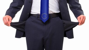 biznesmen, pokazuje puste kieszenie, krawat z logo UE