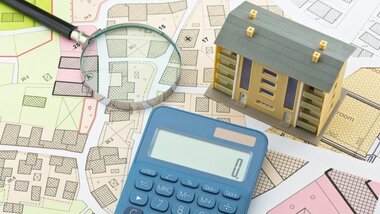 plany. kalkulator, lupa, model domu