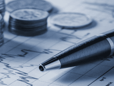 Business financial analysis with pen, coins, and charts.