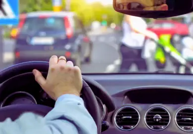 car dashboard with a person holding the wheel, symbolizing driver getting a hardship license