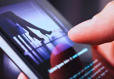 Guy watching an adult film using his phone.