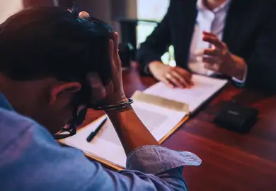 Distressed guy with a handcuff talking to his lawyer.