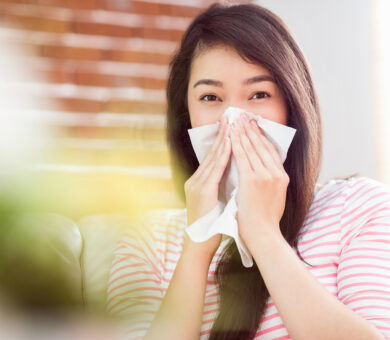 Eine Frau putzt sich die Nase