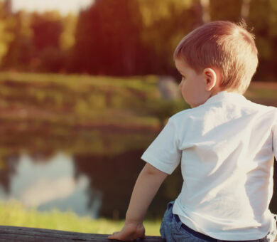 Junge sitzt am Fluss