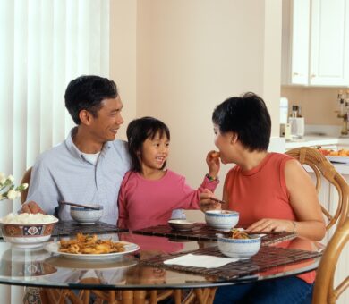 Eltern und Kind sitzen am Esstisch