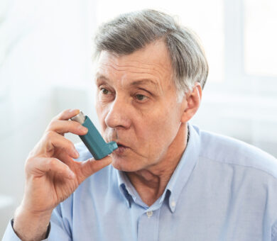 Senior Man Using Asthma Inhaler For Allergies