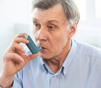Senior Man Using Asthma Inhaler For Allergies