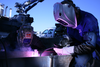 Image of two welders, showing self-shielded flux-cored arc welding (FCAW-S) g application, welding