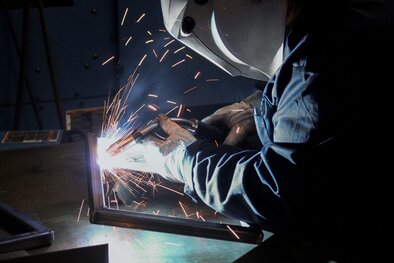 Welder welding a rectangular frame with a MIG gun