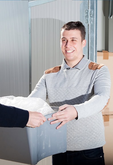 Man with box next to storage unit