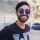 Dark handsome man with beard and blue tinted sunglasses.