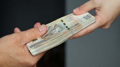 przekazanie pieniędzy, plik banknotów, dwie dłonie