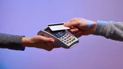 ręka z terminale w dłoni - naprzeciw druga ręka z kartą w dłoni