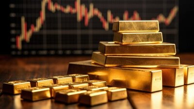 sztabki złota na tle ekranu notowań giełdowych