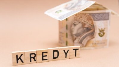 napis kredyt, w tle model domu z banknotów