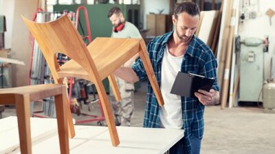 produkcja mebli, mężczyzna trzymający krzesło