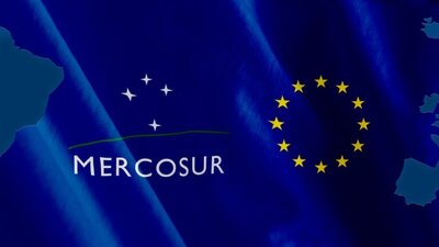 logo Mercosur i UE na niebieskim tle, zarys Europy i Ameryki Południowej