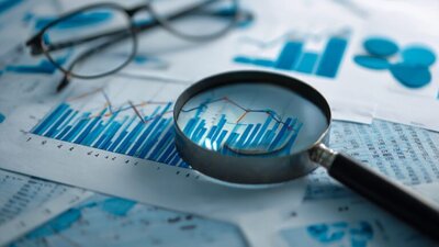 kartki z wykresami, lupa, okulary