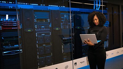 software engineer standing beside server racks