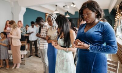 a woman in a blue dress praying intimately