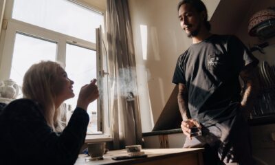 a couple talking to each other in the kitchen