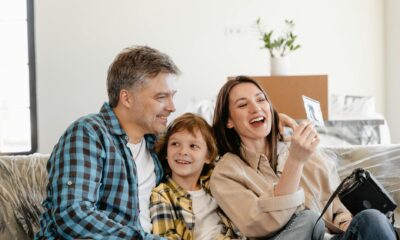 man and woman smiling while holding white smartphone