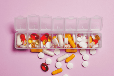 A pill organizer filled with various colorful pills and capsules.