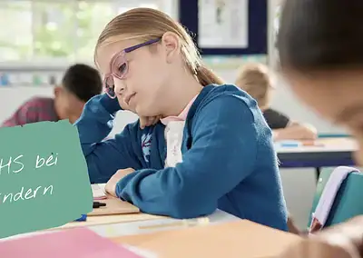 ADHS bei Kindern. Kind sitzt genervt oder müde oder gelangweilt am Tisch in der Schule