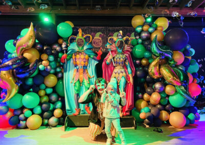 people posing in front of Mardi Gras decorations