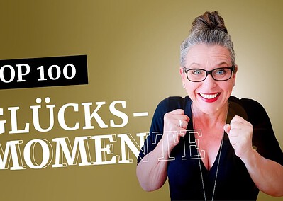 Claudia Ludloff zeigt ihre Top 100 Glücksmomente – lachend, voller Energie und sichtbar begeistert. Emotionales Beitragsbild auf goldfarbenem Hintergrund.